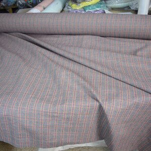 Linen/cotton fabric Mabela Multicolor Tweed. Quite heavy weight striped twill. Very small woven houndstooth pattern, color mix: beige, green, orange, burgundy, navy. Aesthetic, strong and durable, organic, antistatic, breathing, pleasant to touch.