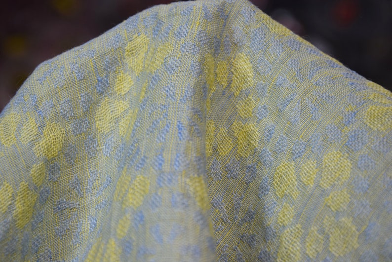 Pure linen fabric Flora Breezy. Floral geometric jacquard pattern woven from pastel yellow and pastel blue colors. Pattern repeats at each 6cm. The oposite sides of the fabric are different but both sides can be used as a right side.