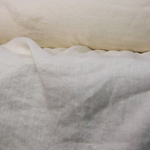 Pure linen fabric. It has a very slight tint of creamy/yellowish/grayish and even a pinkish at the same time, very pale, milky, smooth and buttery. The fabric is middle weight, strong and durable, densely and plain woven, not sheer.