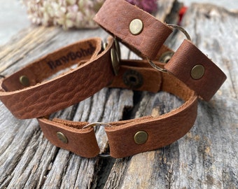 Soft leather unisex cuff with oxidized metal ring and antique brass snaps.