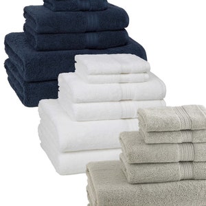 May include: A set of three bath towel stacks in navy blue, white, and gray. Each stack includes a hand towel, bath towel, and washcloth.