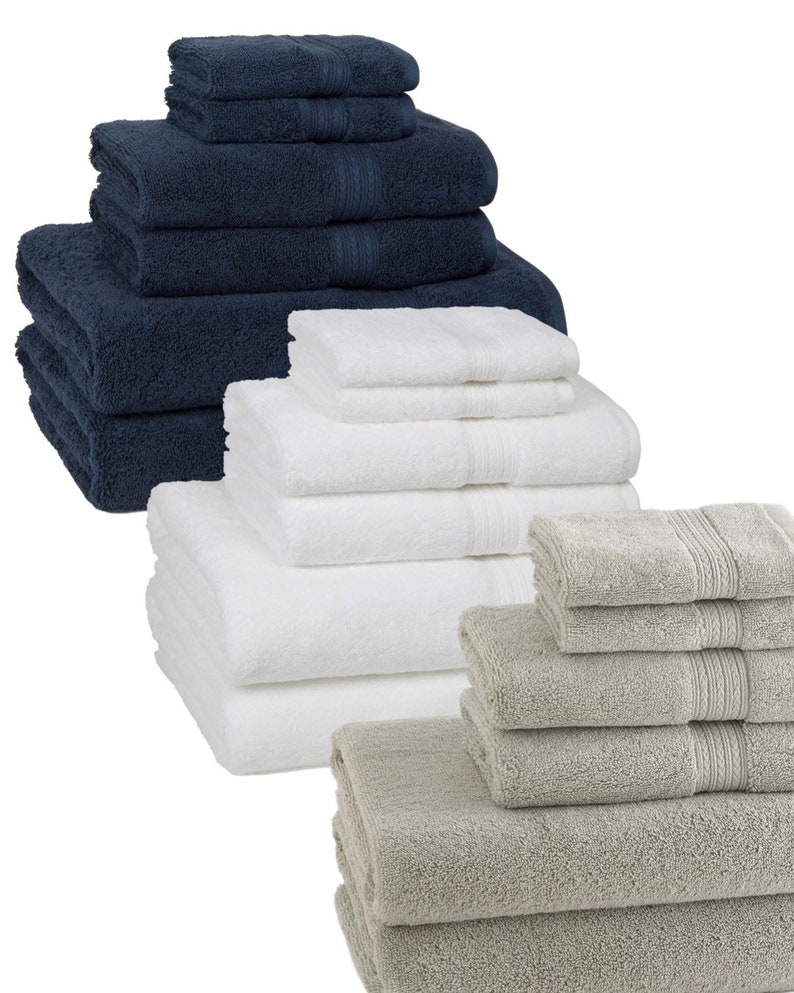 May include: A set of three bath towel stacks in navy blue, white, and gray. Each stack includes a hand towel, bath towel, and washcloth.