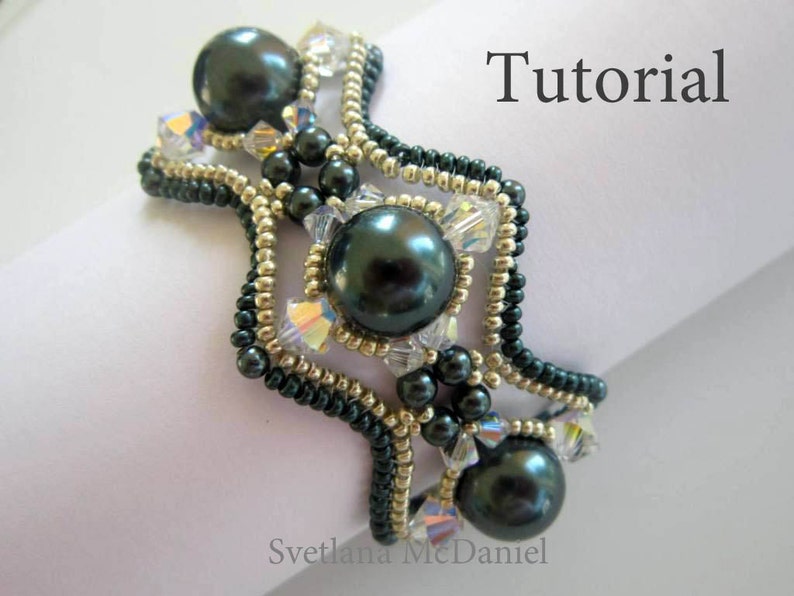 May include: A beaded bracelet with a dark green and gold color scheme. The bracelet features a geometric design with multiple rows of beads and three large, dark green pearls. The text "Tutorial" is visible in the upper right corner of the image.