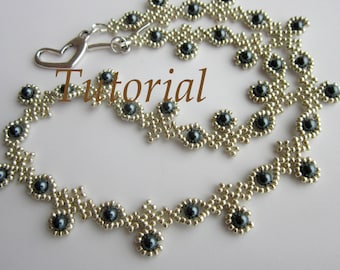 May include: A silver and dark gray beaded necklace with a heart-shaped clasp. The necklace features a repeating pattern of small silver beads and larger dark gray beads.