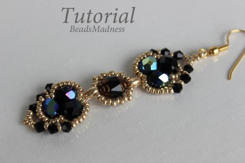 May include: Gold beaded earrings with black and iridescent glass beads. The earrings are long and dangle. The beads are arranged in a pattern of three hearts. The earrings are called "Tutorial BeadsMadness".