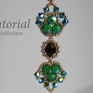 May include: A beaded pendant with green and blue crystals, gold beads, and a brown crystal in the center. The pendant is hanging from a gold chain. The text "Tutorial BeadsMadness" is visible in the top left corner of the image.