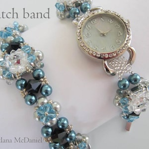 May include: A silver watch with a white face and crystal accents. The watch band is made of blue, black, and silver beads.