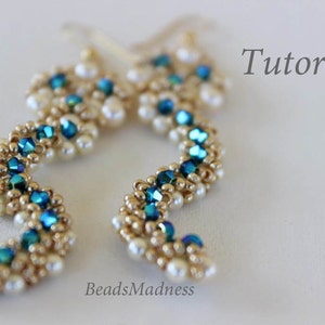 Pode incluir: Um par de brincos feitos à mão com um design de contas douradas e azuis. Os brincos têm a forma de um 'S' e têm uma conta de aparência perolada na parte inferior. Os brincos são etiquetados como "BeadsMadness" e "Tutorial".