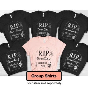 Op de afbeelding: Vijf zwarte T-shirts met witte tekst die "R.I.P. twenties birthday crew" zegt en &eacute;&eacute;n roze T-shirt met witte tekst die "R.I.P. twenties birthday girl" zegt.