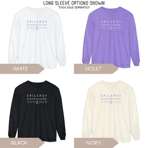 Pu&ograve; includere: Quattro magliette a maniche lunghe in bianco, viola, nero e avorio. Ogni maglietta presenta la scritta "EPILEPSY awareness" con un nastro e cuori. Le magliette sono esposte con etichette colorate.