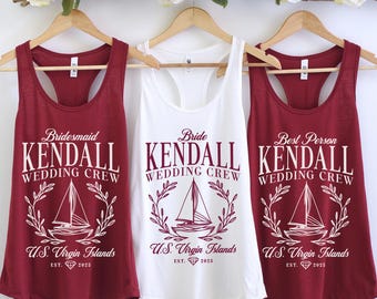 May include: Three tank tops with the text "Kendall Wedding Crew" in white lettering on a maroon background. The tank tops are labeled "Bridesmaid", "Bride", and "Best Person". Each tank top features a white sailboat graphic with a wreath of leaves around it and the text "U.S. Virgin Islands Est. 2023".