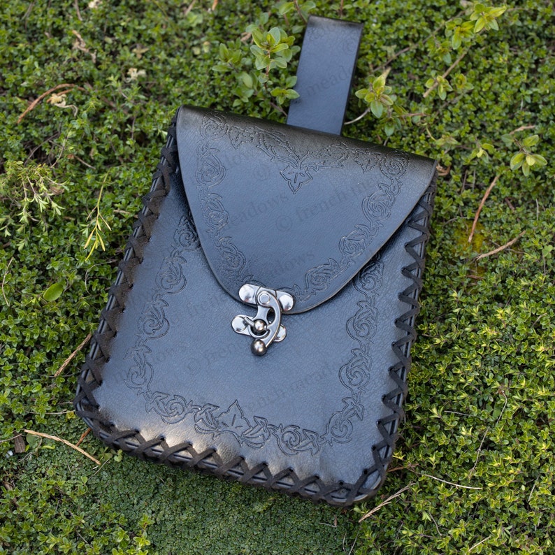 Elven Medieval Belt Pouch with ornate scroll design in black vegan leather on green grass, featuring decorative clasp and belt loop