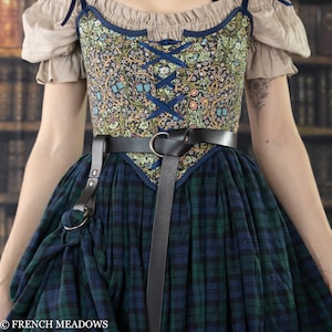 Leather Skirt Hikes shown on renaissance dress with floral bodice and plaid skirt, attached to black leather belt