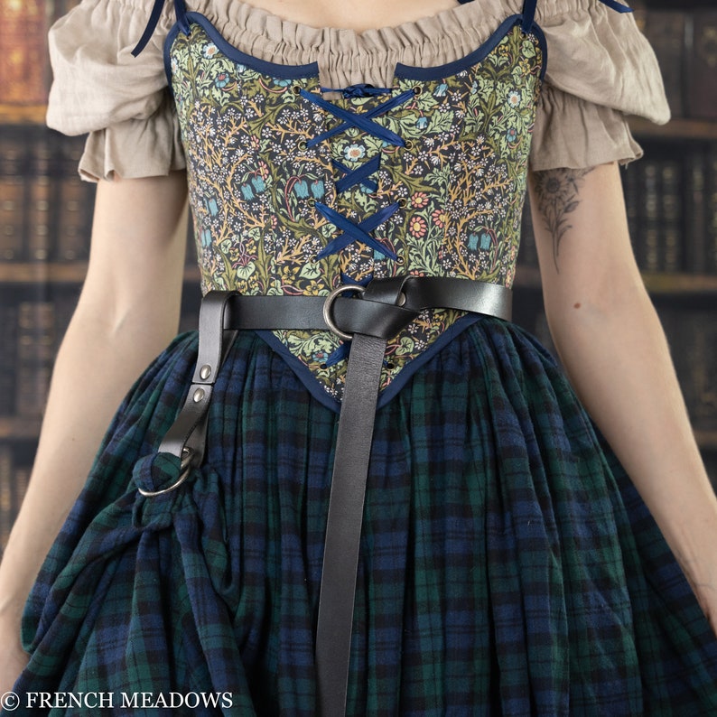 Leather Skirt Hikes shown on renaissance dress with floral bodice and plaid skirt, attached to black leather belt