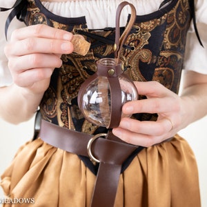 Potion Bottle Holder: Clear glass vial in brown leather strap attached to decorative Renaissance-style costume belt