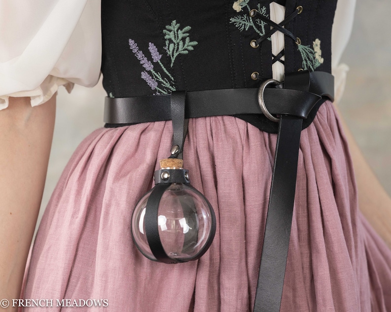 Potion bottle holder attached to black leather belt against floral corset and dusty pink renaissance skirt
