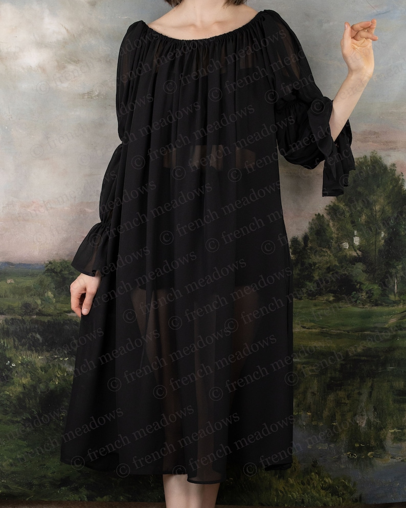 Black Chiffon Long Sleeve Chemise shown off-shoulder with flowing fabric against pastoral backdrop, showcasing sheer elegant design