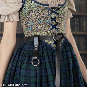 Leather Skirt Hikes shown on plaid renaissance dress with floral bodice and O-ring attachments for lifting skirt layers
