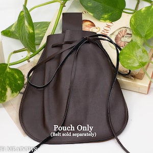 A brown leather pouch with a drawstring closure. The pouch is tied with a black ribbon and has a brown leather strap.