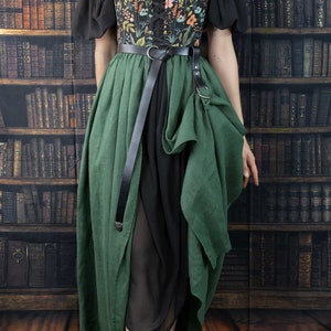 A black and green dress with a floral print bodice and a long, flowing skirt. The dress has a lace-up bodice and a belt with a metal buckle.