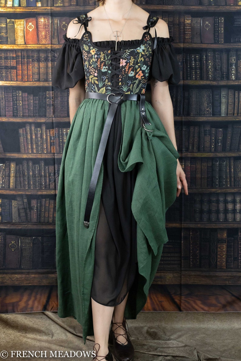 A black and green dress with a floral print bodice and a long, flowing skirt. The dress has a lace-up bodice and a belt with a metal buckle.