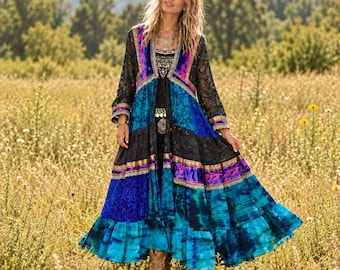 May include: A long-sleeved duster coat featuring a vibrant patchwork design in shades of blue, black, and purple. The garment includes intricate lace detailing, velvet panels, and a ruffled hemline, creating a layered, flowing silhouette.