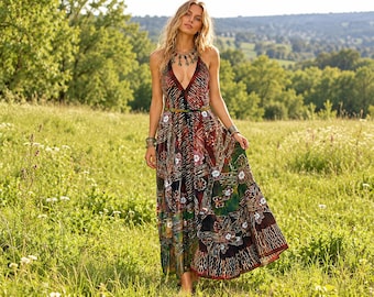 May include: A floor-length sleeveless maxi dress featuring a deep V-neckline and a vibrant, multi-coloured patchwork pattern with intricate floral and abstract motifs in shades of red, green, brown, and black, finished with a thin waist belt.