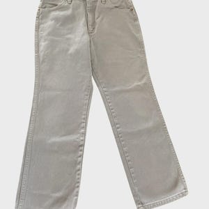 Op de afbeelding: Een lichtgrijze spijkerbroek. De jeans heeft een klassiek ontwerp met vijf zakken, een knoop- en ritssluiting en riemlussen. De jeans heeft een neutrale kleur en is geschikt voor diverse outfits.