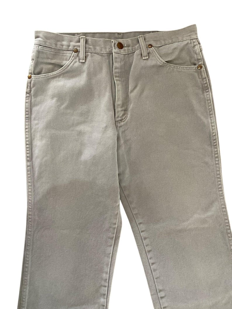 Op de afbeelding: Een lichtgrijze spijkerbroek. De jeans heeft een klassiek ontwerp met vijf zakken en een knoop- en ritssluiting. De jeans is gemaakt van duurzaam denim materiaal en heeft een rechte pijp.