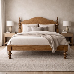 May include: A wooden bed frame with a curved headboard and turned spindle posts, featuring a white duvet, a beige throw blanket, and several pillows. Two matching wooden nightstands with white lamps are positioned on either side of the bed.