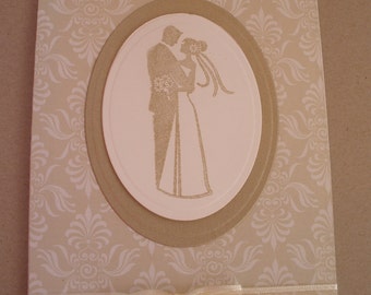 Handmade Wedding card in gold with a stamped image of a bride and groom.
