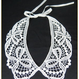 May include: White lace collar with a delicate floral pattern and a ribbon tie.