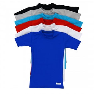 May include: A stack of eight short-sleeved t-shirts in various colors, including blue, red, white, gray, and turquoise. The shirts are folded and stacked on top of each other. The bottom shirt is blue and has a small white tag with the word "halo" on it.