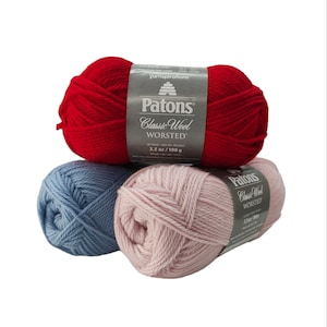 May include: Three skeins of Patons Classic Wool Worsted yarn. The skeins are red, blue, and pink. Each skein is labeled with the brand name and weight: 3.5 oz / 100 g.