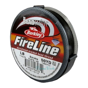 May include: A spool of Smoke-colored FireLine microfused braided bead thread. The spool is black with a red and yellow label featuring the Berkley and FireLine logos. The label indicates 50 yards of thread.