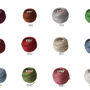 Puede incluir: Una colecci&oacute;n de doce carretes de hilo de bordar en varios colores, incluyendo tonos de rojo, verde, azul y gris. Cada carrete tiene un n&uacute;mero impreso, como 35, 300, 415 y 702. Los carretes est&aacute;n dispuestos en tres filas de cuatro.
