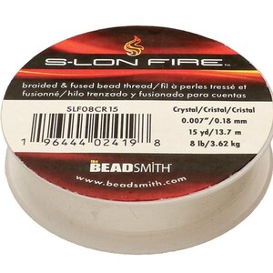 May include: A spool of S-Lon Fire braided and fused bead thread. The label is red and black with white text, including the brand name and product details. The thread is crystal, 0.007"/0.18 mm, 15 yards/13.7 m, and 8 lb/3.62 kg.