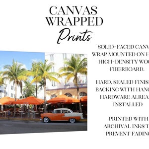 May include: A vintage orange car parked in front of a cafe with orange umbrellas. The cafe is located in a tropical setting with palm trees and a white building. The image is a canvas print with a solid-faced canvas wrap mounted on hard, high-density wood fibreboard. The print has a hard, sealed finished backing with hanging hardware already installed. It is printed with archival inks to prevent fading.
