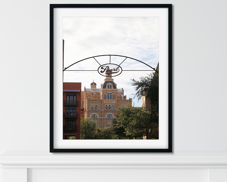 May include: A black and white photo of a building with a sign that says "Pearl" above it. The building is a historic brick building with a tower and a clock.