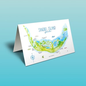 Op de afbeelding: Een aquarel-illustratie van Sanibel Island, Florida, met een kaart van het eiland en het omliggende water. De kaart toont verschillende bezienswaardigheden, waaronder stranden, parken en een vuurtoren. De illustratie is in tinten blauw, groen en bruin.