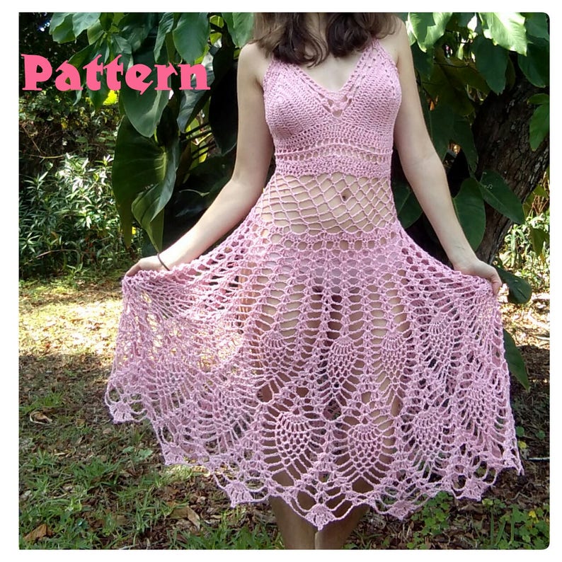 May include: A pink crochet dress with a delicate, lacy pattern. The dress has a fitted bodice and a flowing skirt.