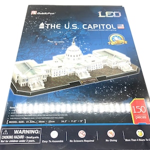 May include: A 150-piece 3D puzzle of the U.S. Capitol building with LED lighting. The box shows a model of the building with a blue and white map in the background. The box also includes the text "The U.S. Capitol" and "Architecture Model-LED Lighting".