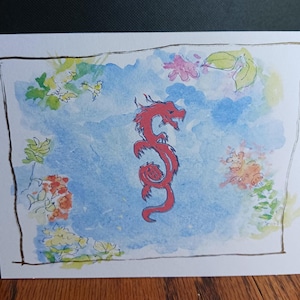 May include: A watercolor painting of a red dragon with a blue background and white flowers. The dragon is curled up in a spiral shape.