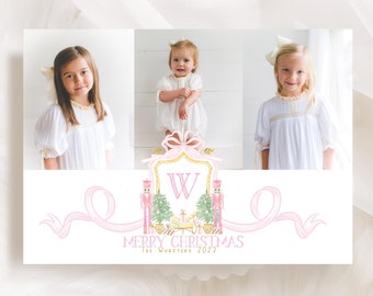 May include: A Christmas card featuring three children in white dresses. The card has a pink and gold design with a large letter "W" and the words "Merry Christmas" and "The Wuesties 2022".