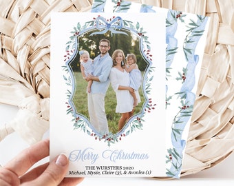 May include: A Christmas card featuring a family of four in a watercolor wreath with a blue ribbon. The text reads "Merry Christmas, The Wursters 2020, Michael, Mysie, Claire (3), & Avonlea (1)"