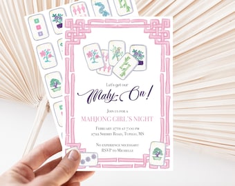 Puede incluir: Una invitación rosa y blanca para una Noche de Chicas de Mahjong con un borde decorativo y fichas de Mahjong. La invitación incluye el texto "Let's get our Mahy-On!" y los detalles del evento. La invitación se sostiene frente a una hoja de palma seca.