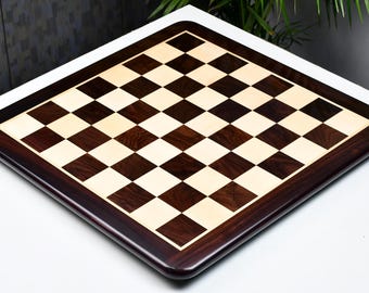 May include: A wooden chessboard with a dark brown and light wood design. The board has a dark brown border.