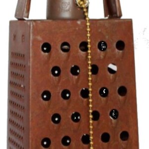 May include: A rustic, brown metal pendant light fixture crafted from a repurposed cheese grater. The fixture features a rectangular shape with numerous holes, a pull chain, and a brown cord for hanging. The design evokes a vintage, industrial aesthetic.