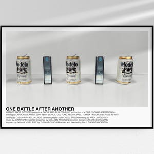 Peut inclure: Une affiche encadrée avec trois canettes de bière Modelo et deux objets rectangulaires noirs. Les canettes sont argentées avec des détails dorés et le logo Modelo. Le texte "ONE BATTLE AFTER ANOTHER" est en bas de l'affiche.