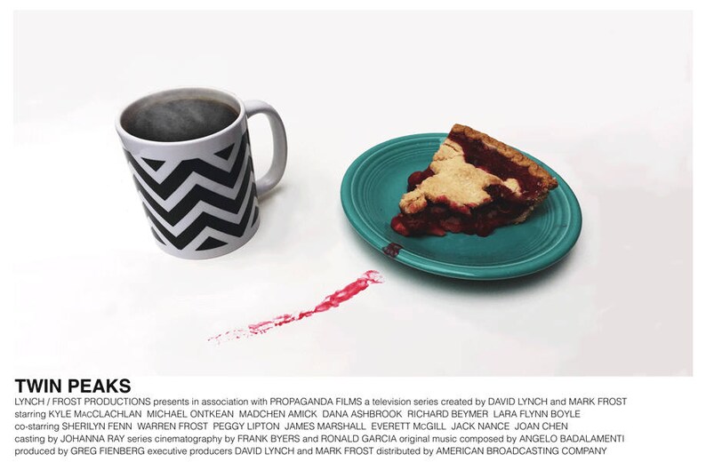 May include: A white mug with a black and white chevron pattern, filled with coffee, sits on a white surface. A slice of cherry pie on a teal plate is to the right of the mug. A red stain is on the surface between the mug and the plate. The text "TWIN PEAKS" is at the bottom of the image.